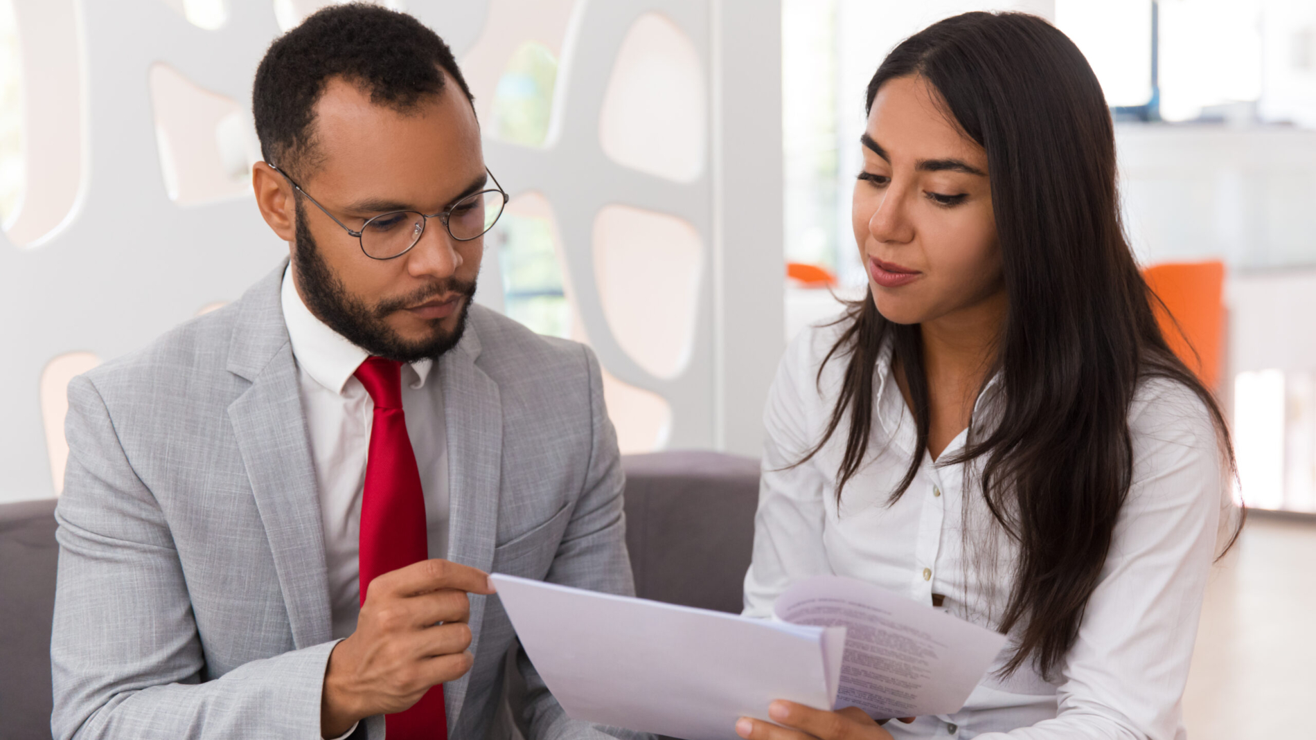 Businesswoman consulting legal expert. Business woman showing and giving papers to man in suit in office lounge. Document expertise concept