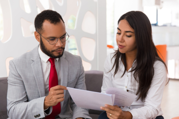 Businesswoman consulting legal expert. Business woman showing and giving papers to man in suit in office lounge. Document expertise concept